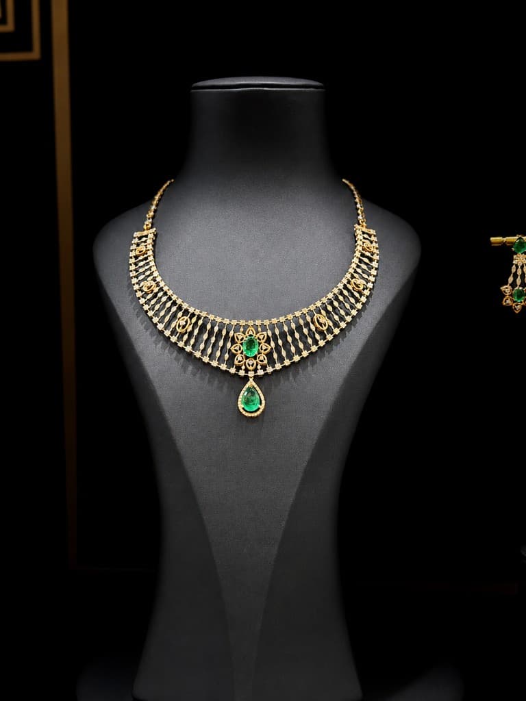 Emerald diamond necklace set with matching earrings on black display bust