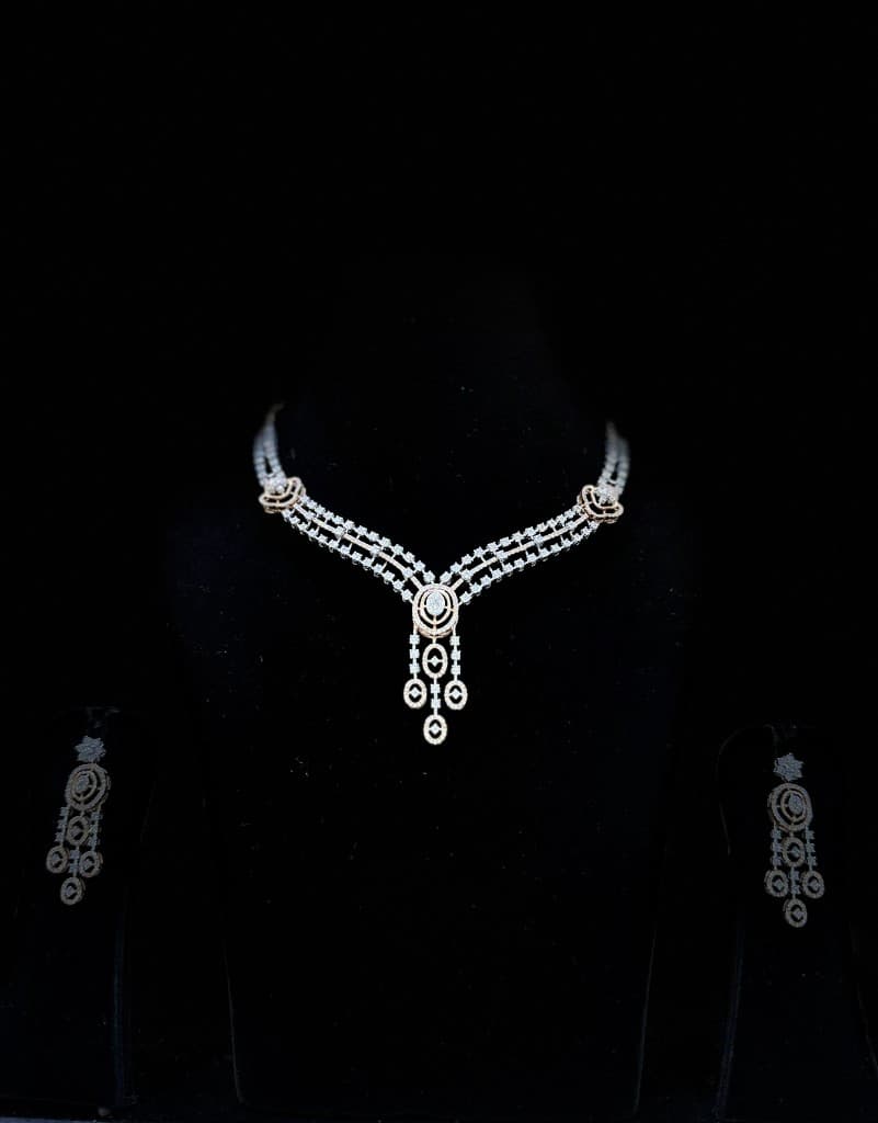 Diamond necklace and earrings in cinematic lighting on black display